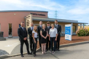 Photo de groupe de l'équipe des pompes funèbres devant l'agence.